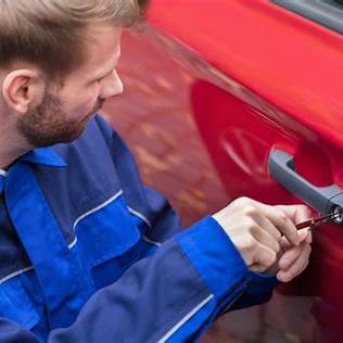 a locksmith opening the door for a car